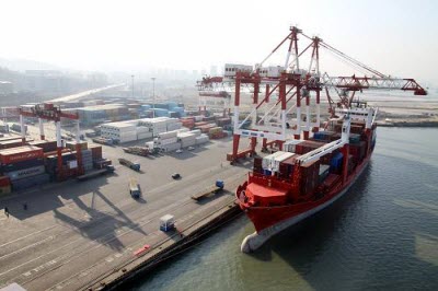 12月23日，一艘集装箱货轮在山东威海港新港区集装箱码头吊卸集装箱。